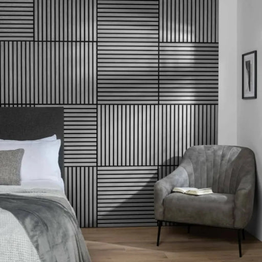 Modern bedroom with geometric square acoustic wall design, gray armchair, and bed.