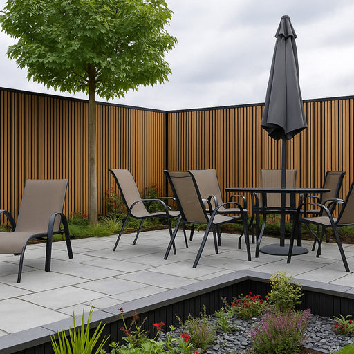Garden setting with patio furniture, table, chairs, and umbrella against a oak slat clad fence.