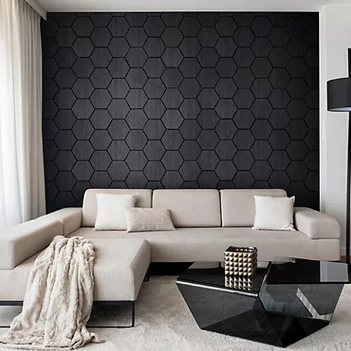 Modern living room with a hexagonal black wall pattern and a beige sectional sofa.